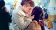A still image from Amazon's holiday ad showing two woman in winter coats kissing in a store.